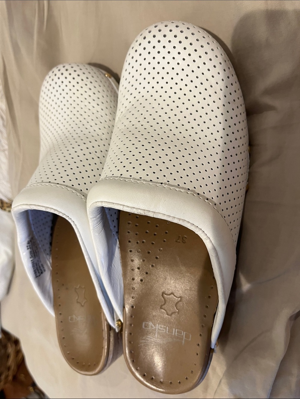 Dansko White Perforated Leather Slip-On Clogs. Some peeling inside.